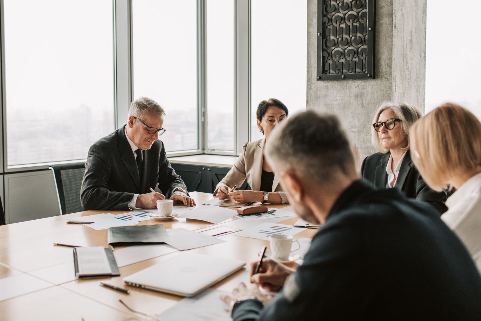 Executives reviewing documents around a boardroom table