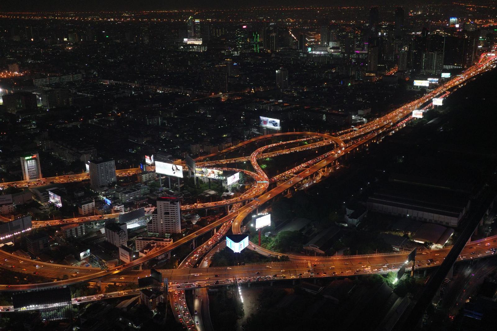 A city seen from above at night, its roads and districts lit